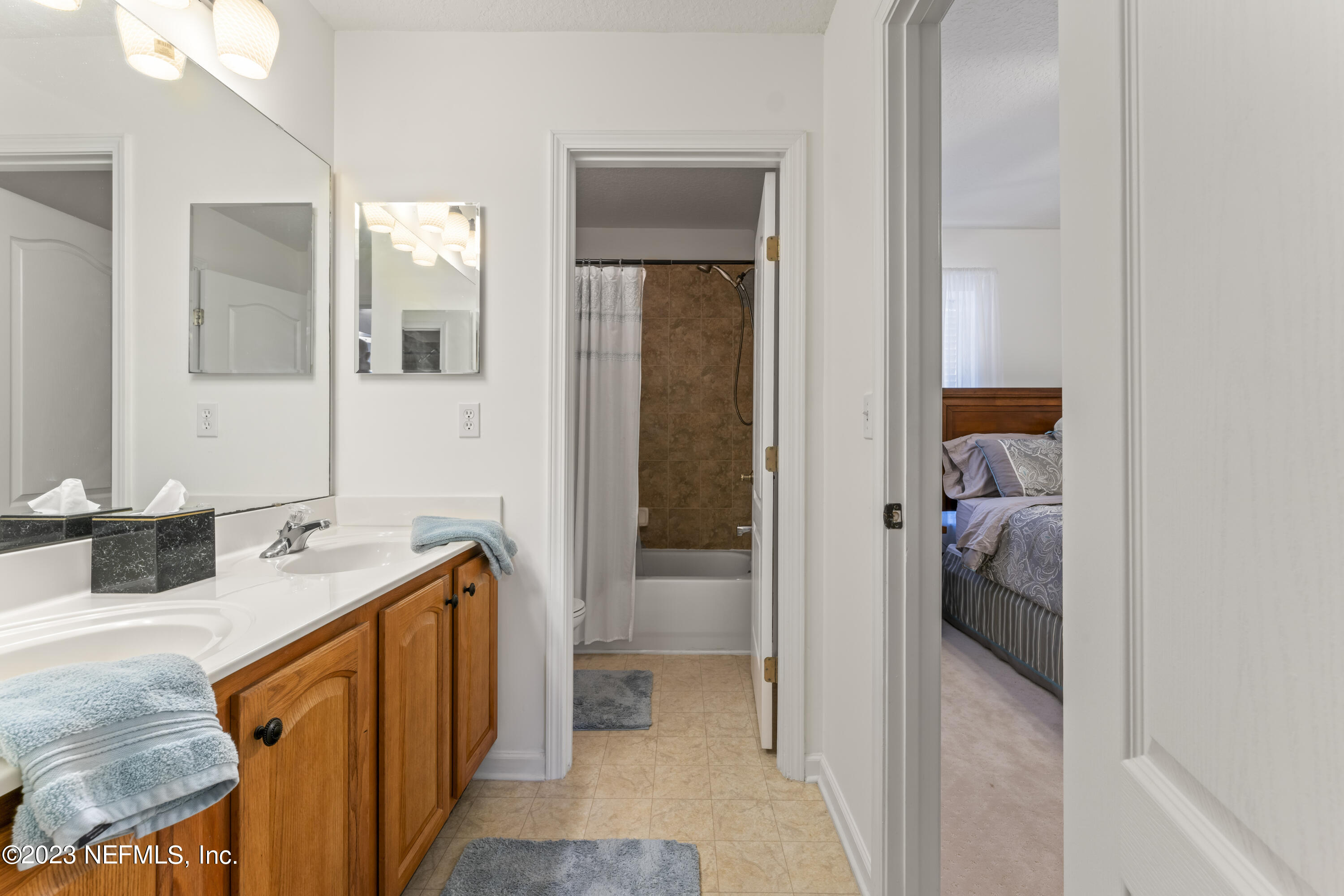 1840 Copper Stone Drive, Unit D Fleming Island, FL 32003 - Photo 29 of 66 a en suite bathroom with a granite countertop sink and a mirror