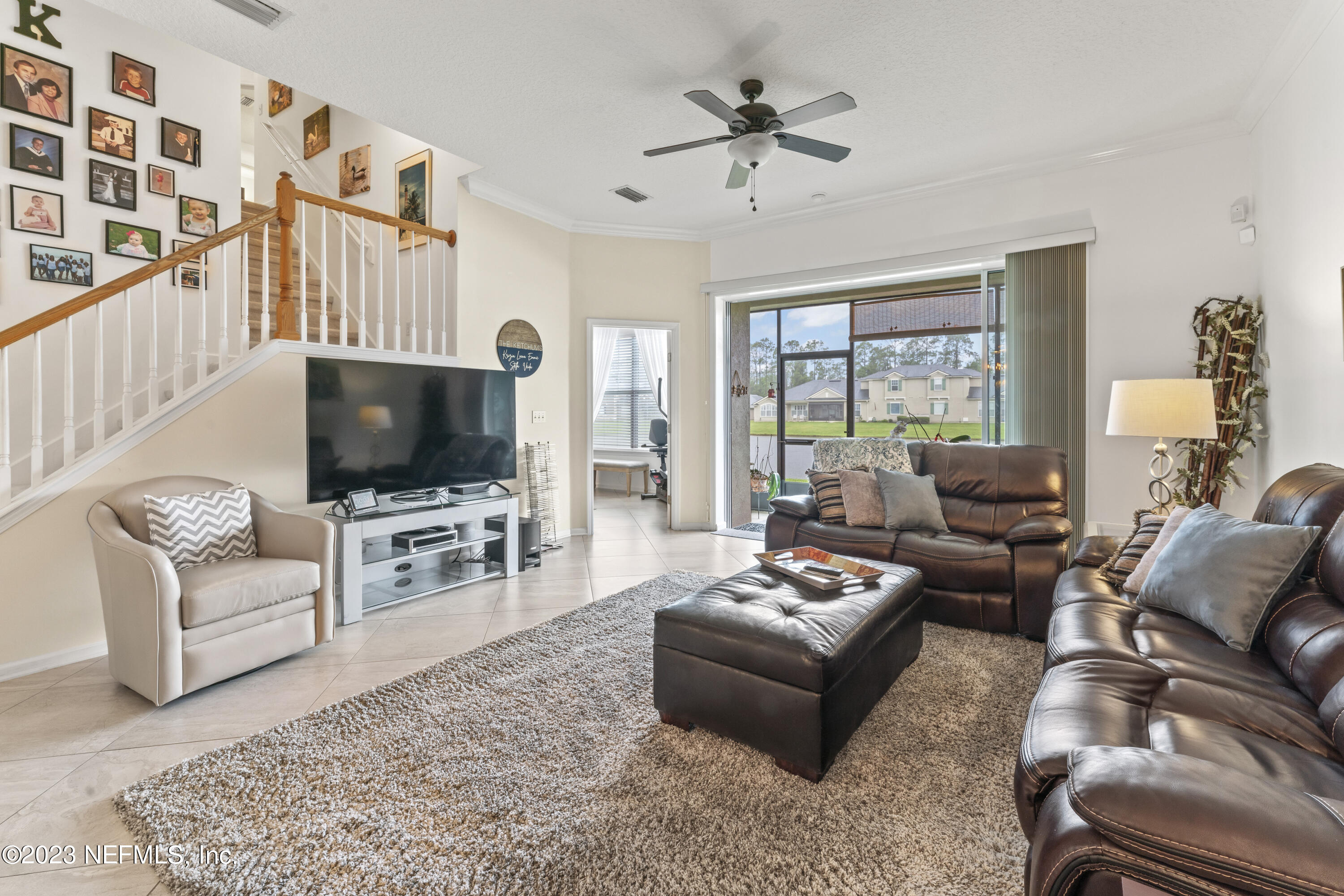 1840 Copper Stone Drive, Unit D Fleming Island, FL 32003 - Photo 3 of 66 a living room with furniture a flat screen tv and a large window
