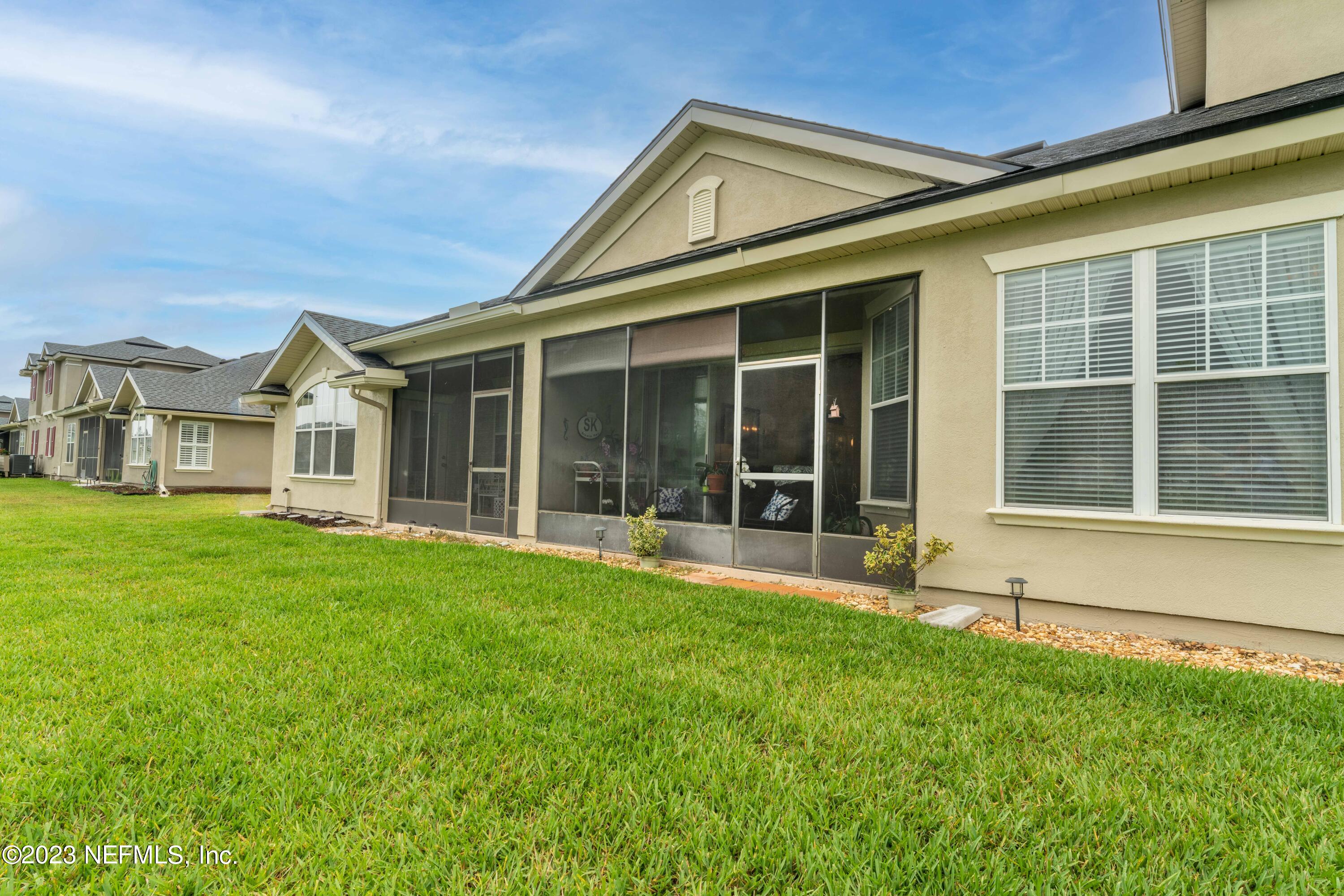 1840 Copper Stone Drive, Unit D Fleming Island, FL 32003 - Photo 36 of 66 a view of a white house with a large window and yard