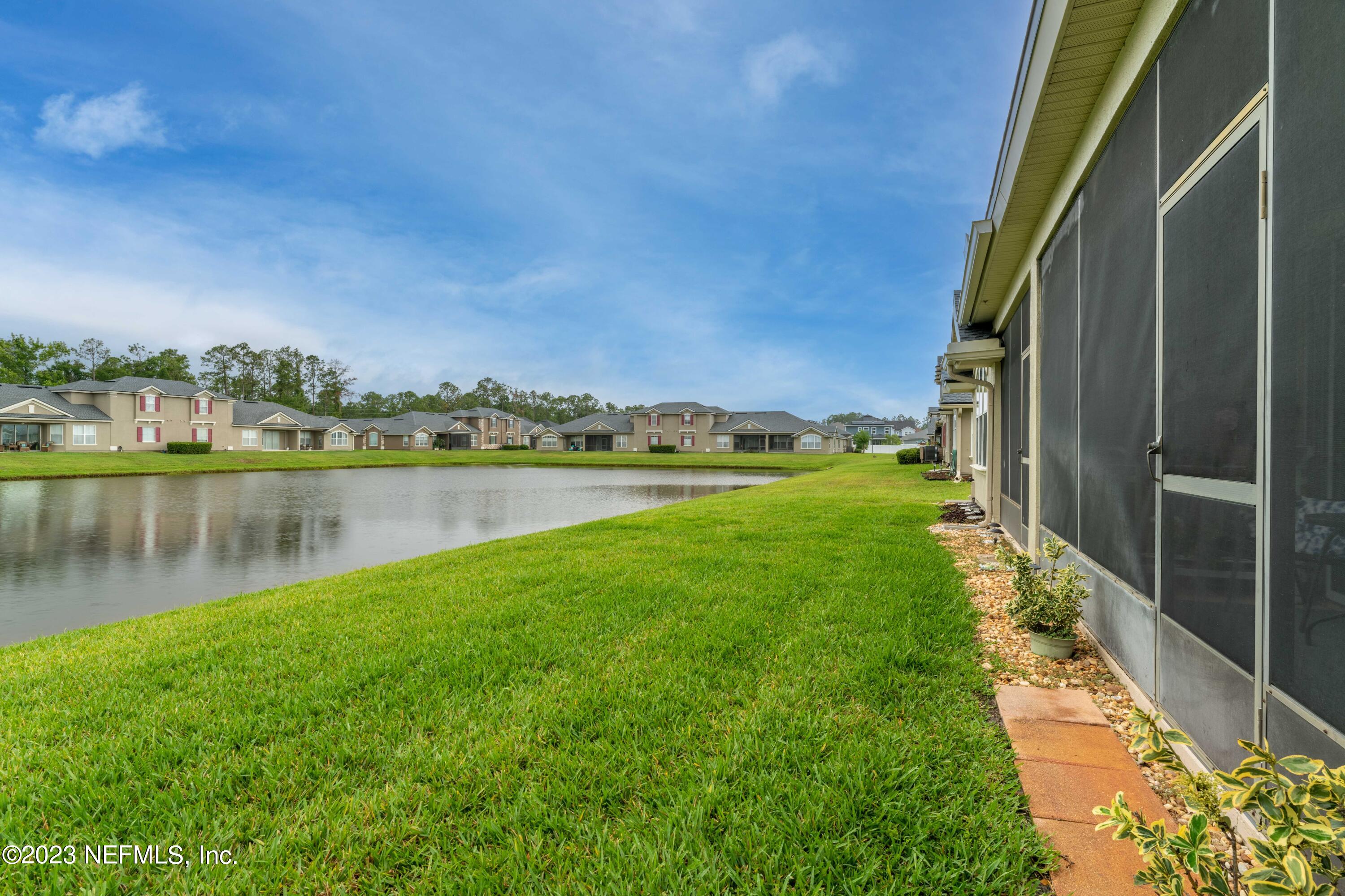 1840 Copper Stone Drive, Unit D Fleming Island, FL 32003 - Photo 38 of 66 a view of a lake with a big yard