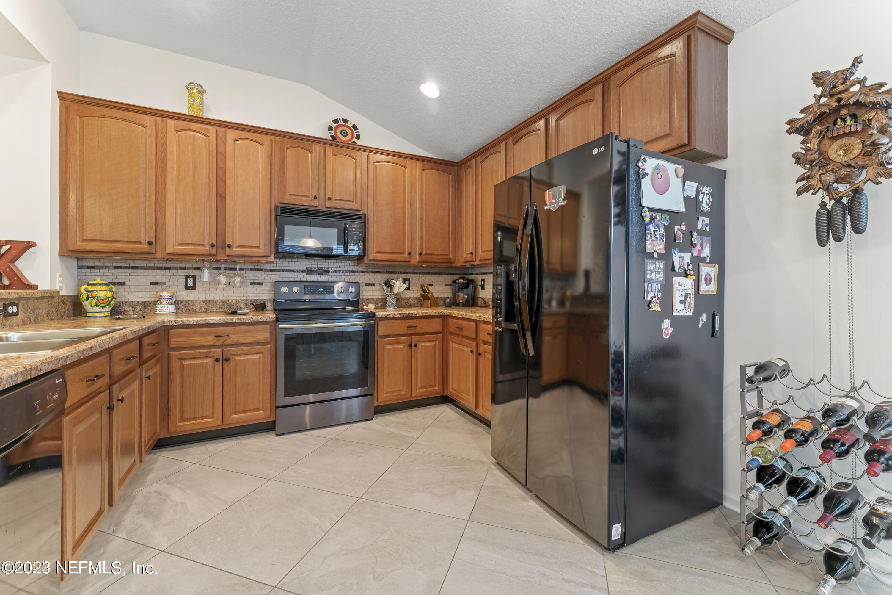 1840 Copper Stone Drive, Unit D Fleming Island, FL 32003 - Photo 54 of 66 a kitchen with stainless steel appliances granite countertop a refrigerator sink and cabinets