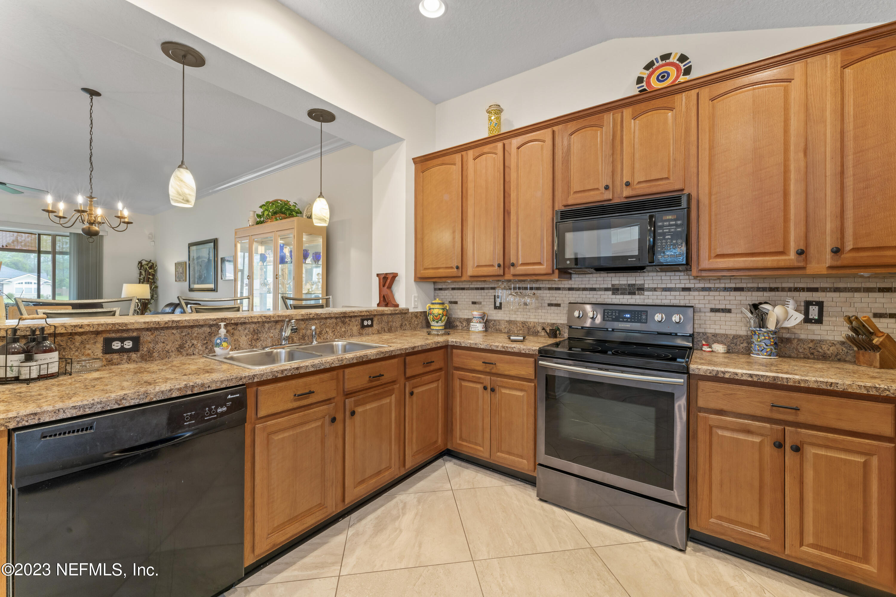 1840 Copper Stone Drive, Unit D Fleming Island, FL 32003 - Photo 6 of 66 a kitchen with stainless steel appliances granite countertop a sink a stove a microwave and cabinets