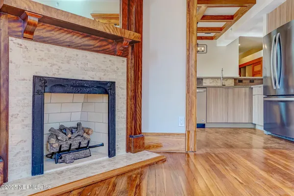 a view of a livingroom with wooden floor and a fireplace