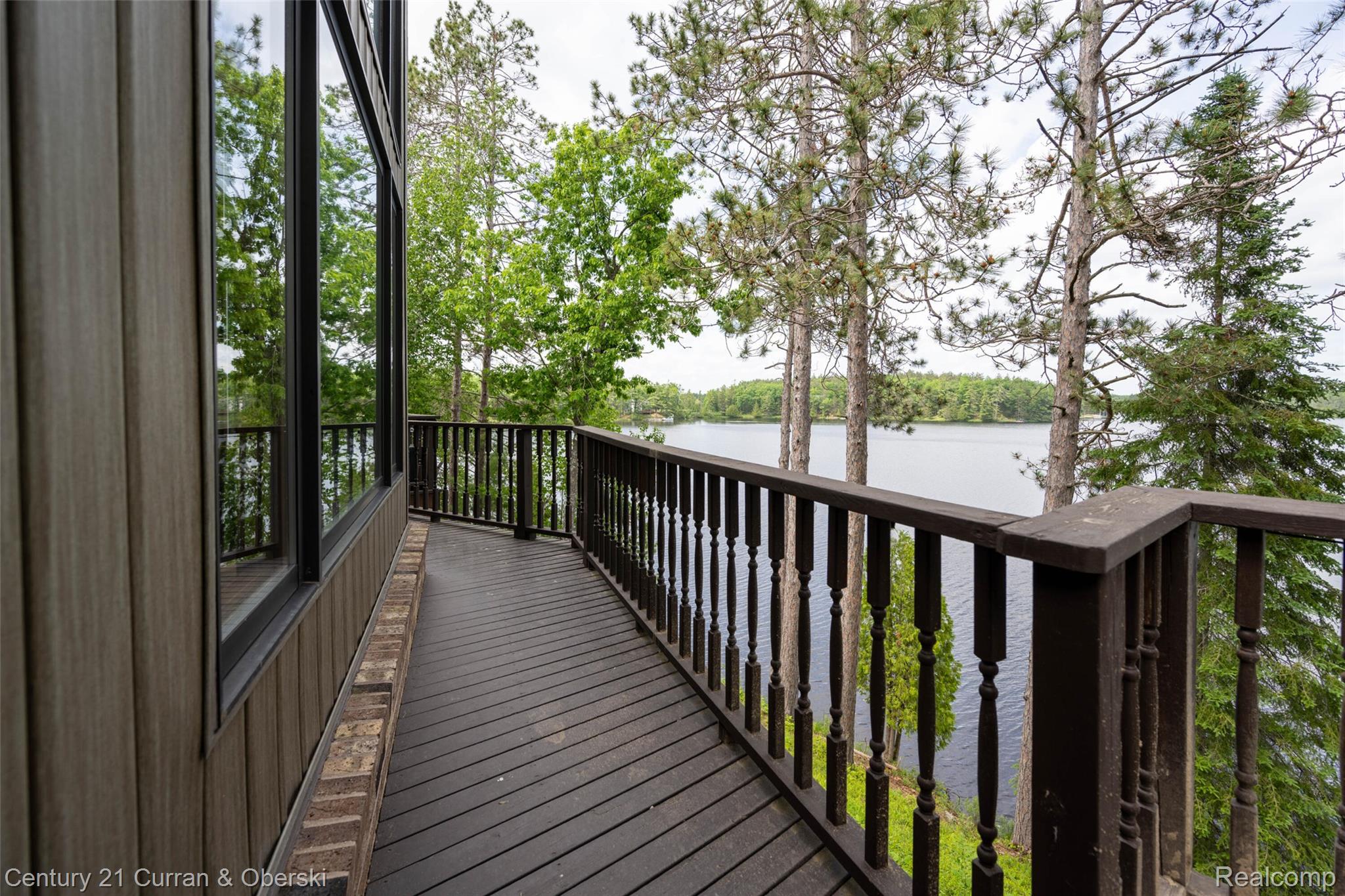 8775 Winding Rdg Drive Millersburg, MI 49759 - Photo 37 of 53 Spacious deck with dark wood-finish flooring and traditional balusters, offering expansive water scenery