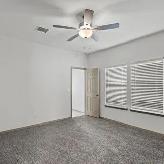 a view of an empty room and a ceiling fan