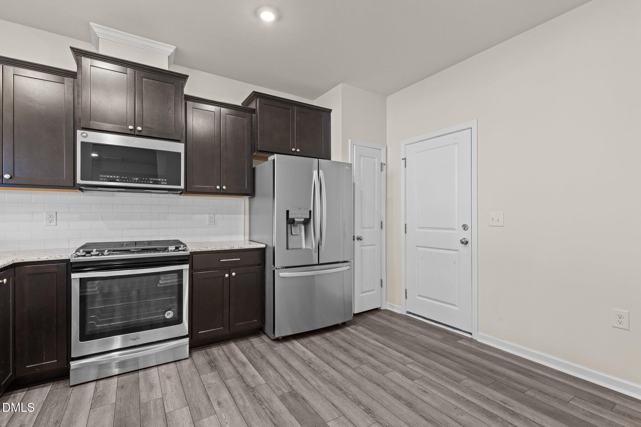 1106 Congleton Place Durham, NC 27703 - Photo 8 of 34 a kitchen with stainless steel appliances and wooden cabinets