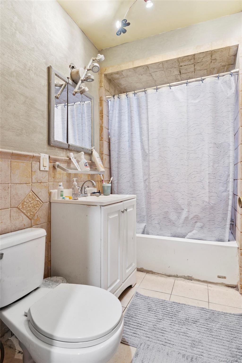 809 Friel Place Brooklyn, NY 11218 - Photo 9 of 19 a bathroom with a sink a mirror a toilet and bathtub