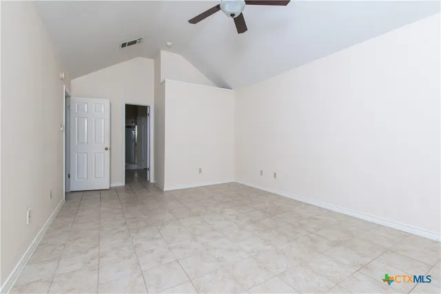 a view of a room with a ceiling fan and window