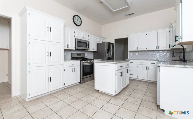 a kitchen with white cabinets and white appliances