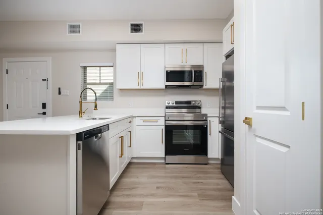 a kitchen with stainless steel appliances granite countertop a sink and a stove