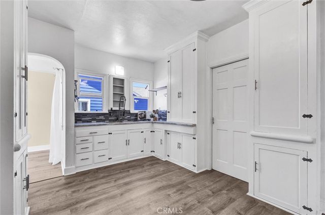 a kitchen with granite countertop white cabinets and white appliances
