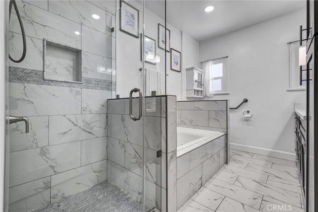 a bathroom with a bathtub a sink a counter and a shower