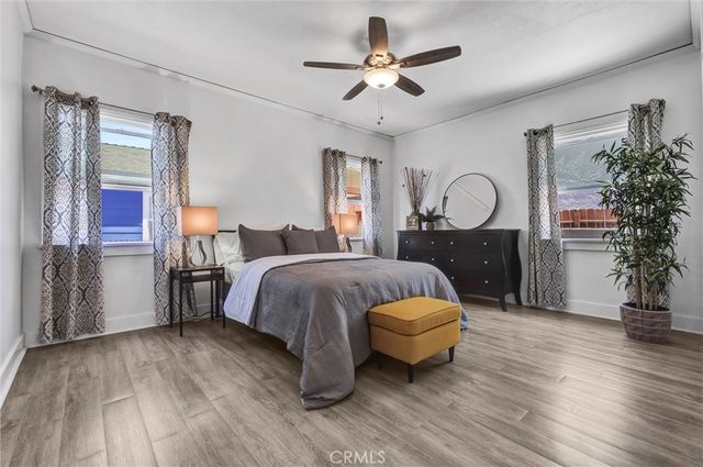 a spacious bedroom with a bed chandelier and windows