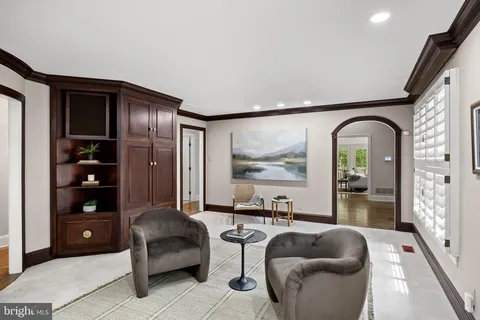 a living room with furniture and a painting on the wall