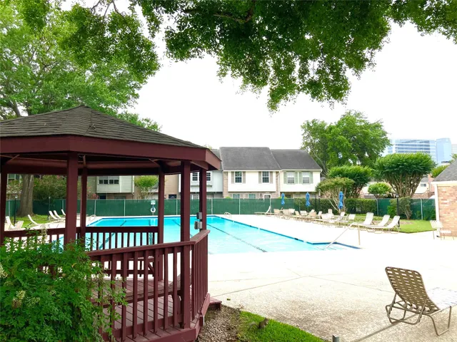 a view of a wooden chairs and bench in the garden