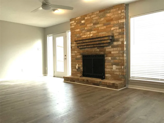 an empty room with wooden floor and fireplace