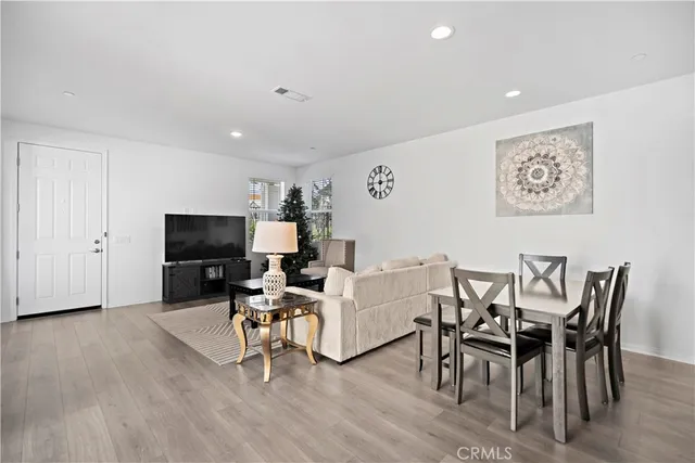 a living room with furniture a flat screen tv and a dining table