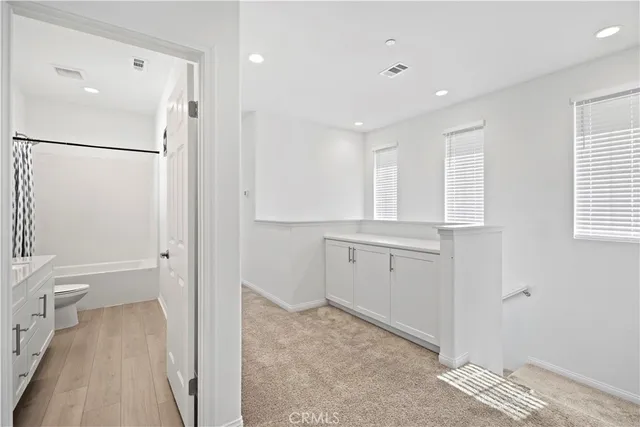a bathroom with a double vanity sink a toilet and a large mirror
