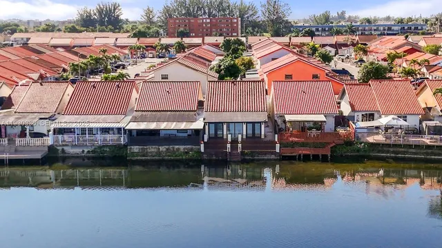 an aerial view of residential houses with outdoor space and lake view