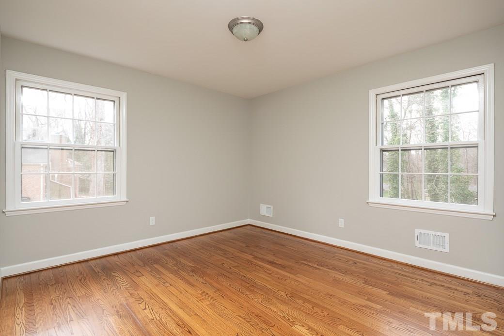 8913 Hunting Trail Raleigh, NC 27613 - Photo 10 of 19 an empty room with wooden floor and windows