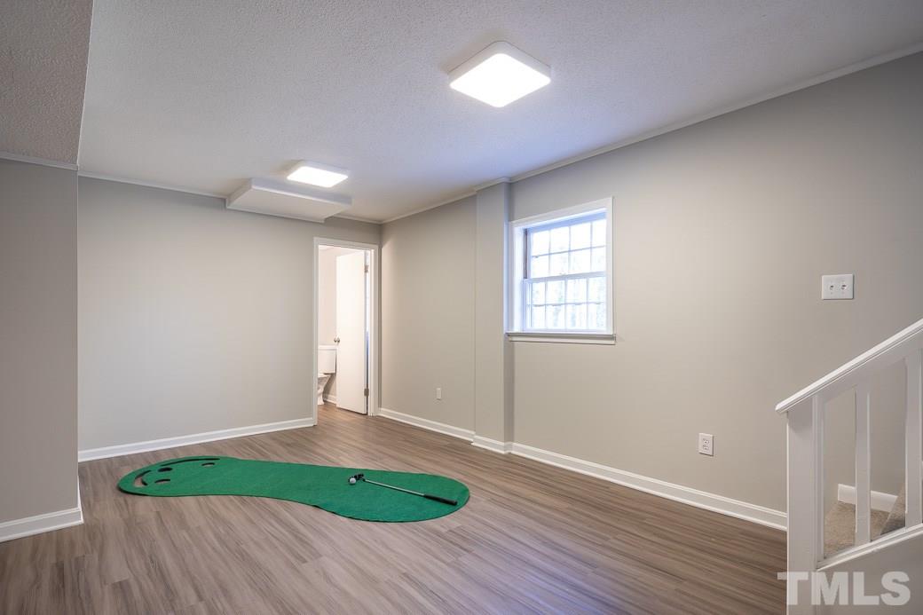 8913 Hunting Trail Raleigh, NC 27613 - Photo 13 of 19 an empty room with wooden floor and windows