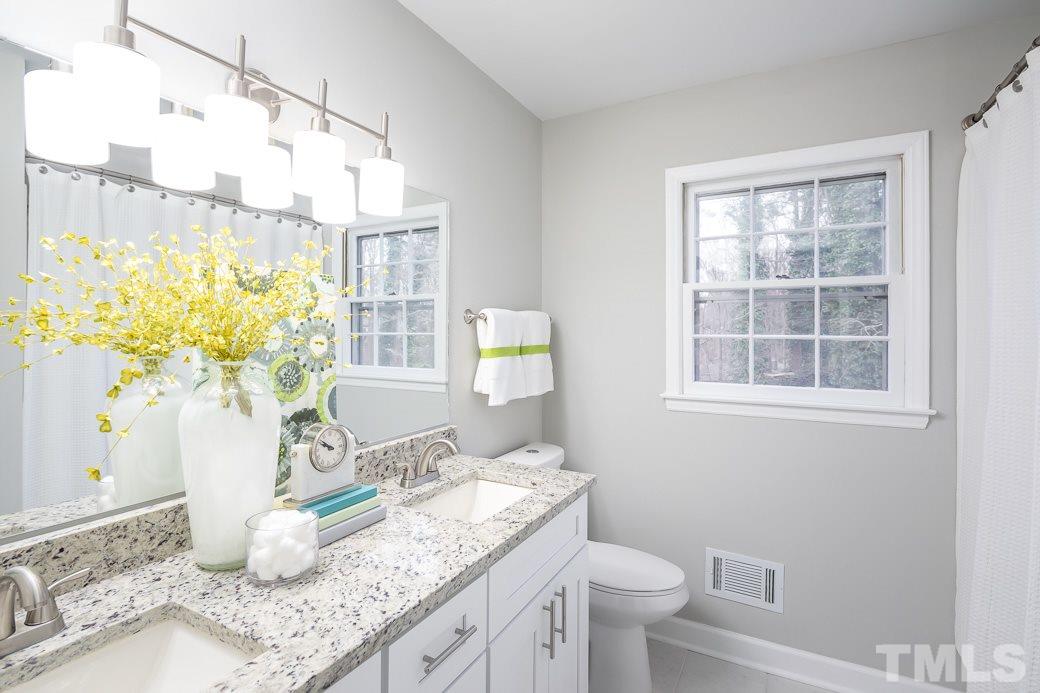 8913 Hunting Trail Raleigh, NC 27613 - Photo 8 of 19 a bathroom with a granite countertop sink and a mirror