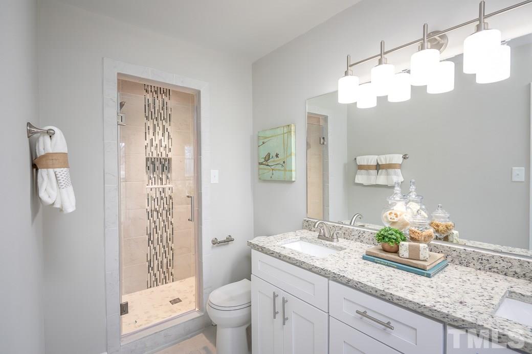 8913 Hunting Trail Raleigh, NC 27613 - Photo 9 of 19 a bathroom with a granite countertop sink a toilet and a large mirror