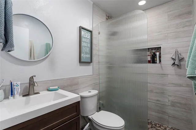 a bathroom with a sink mirror vanity and toilet