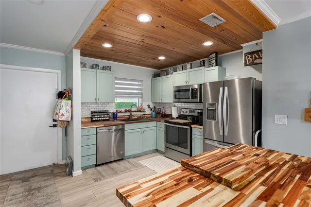 a kitchen with stainless steel appliances granite countertop a refrigerator a stove and a sink