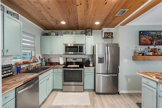 a kitchen with stainless steel appliances granite countertop a refrigerator a stove a sink dishwasher and a microwave oven with cabinets