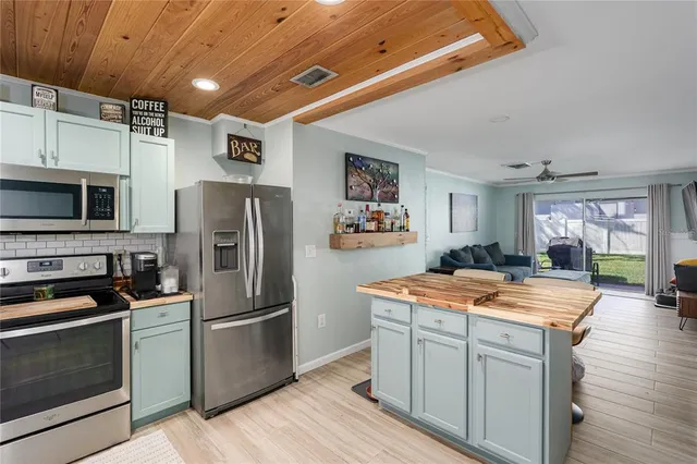 a kitchen with stainless steel appliances granite countertop a refrigerator a stove sink and microwave