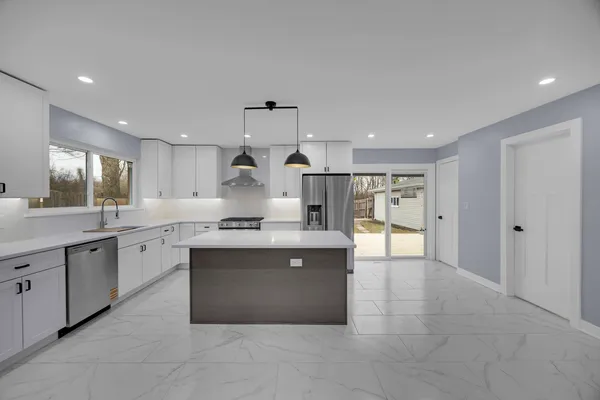a large kitchen with cabinets and wooden floor