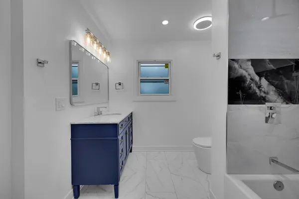 a bathroom with a sink a toilet and mirror