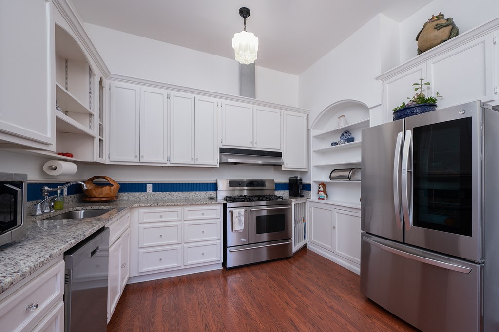 215 7th Street Columbus, GA 31901 - Photo 25 of 64 a kitchen with stainless steel appliances kitchen island granite countertop a refrigerator a stove and a sink