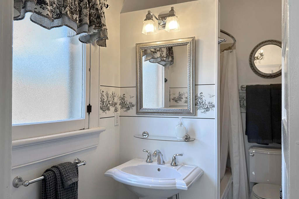 215 7th Street Columbus, GA 31901 - Photo 52 of 64 a bathroom with a sink a mirror and a toilet