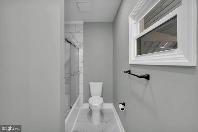 a bathroom with a toilet and a shower