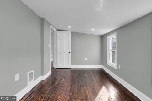a view of hallway with a large window and wooden floor