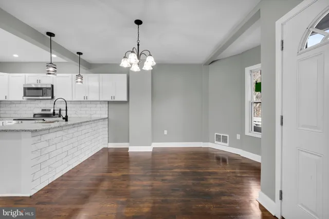 a view of a kitchen with a sink dishwasher a refrigerator and wooden floor