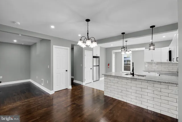 a view of a kitchen with a sink and wooden floor