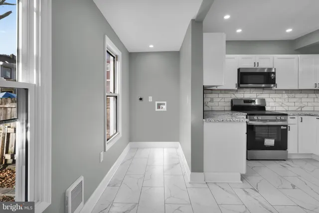 a kitchen with stainless steel appliances granite countertop a refrigerator and a stove top oven
