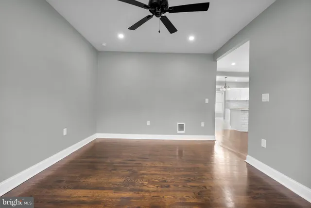 a view of an empty room with window and wooden floor