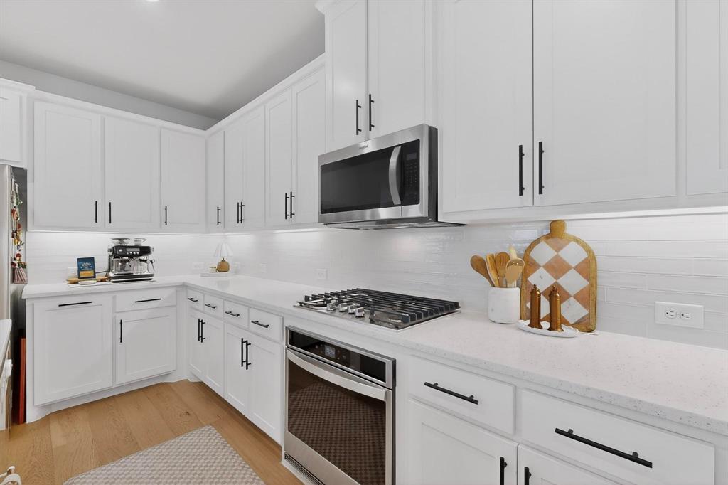 207 Buffalo Boulevard Rhome, TX 76078 - Photo 6 of 40 Gleaming Nuvo Quartz makes the gas cooktop pop.