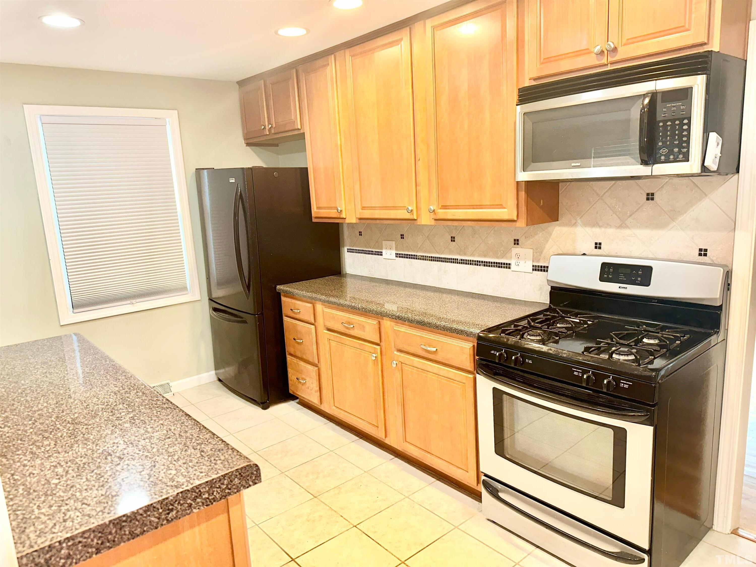 700 Mial Street Raleigh, NC 27608 - Photo 6 of 15 a kitchen with stainless steel appliances granite countertop a stove a sink and a refrigerator