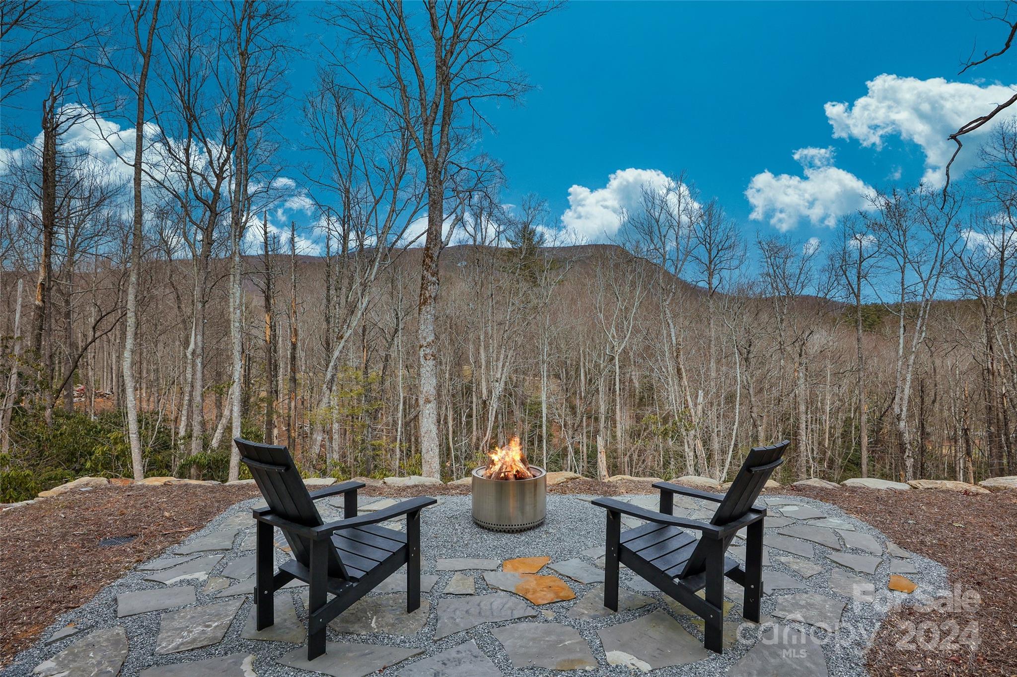 510 Boiling Springs Road Sapphire, NC 28774 - Photo 44 of 48 a view of a chairs and table in the back yard of the house