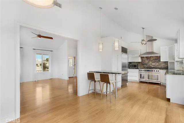 a kitchen with granite countertop a stove a sink and a refrigerator