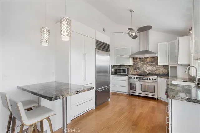 a kitchen with granite countertop a stove cabinets and refrigerator