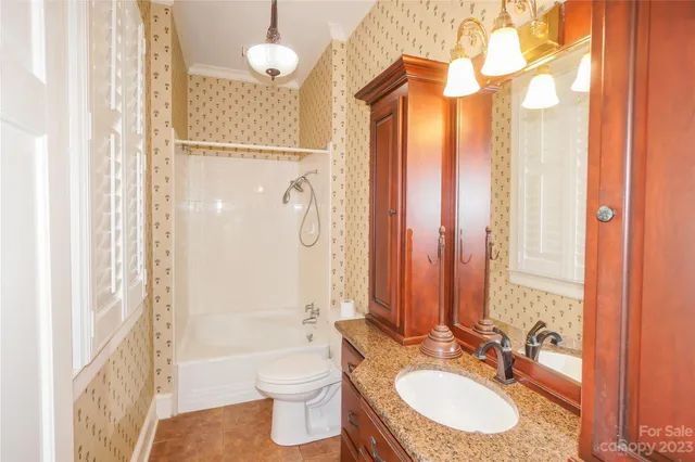 a bathroom with a double vanity sink toilet mirror and shower