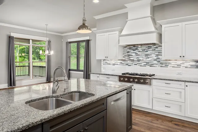 a kitchen with granite countertop a sink stove and cabinets