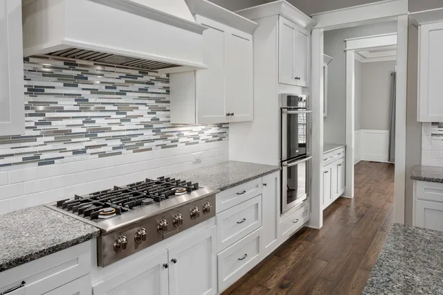 a kitchen with white cabinets and appliances