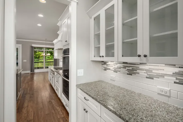 a kitchen with stainless steel appliances granite countertop a stove and a wooden floors